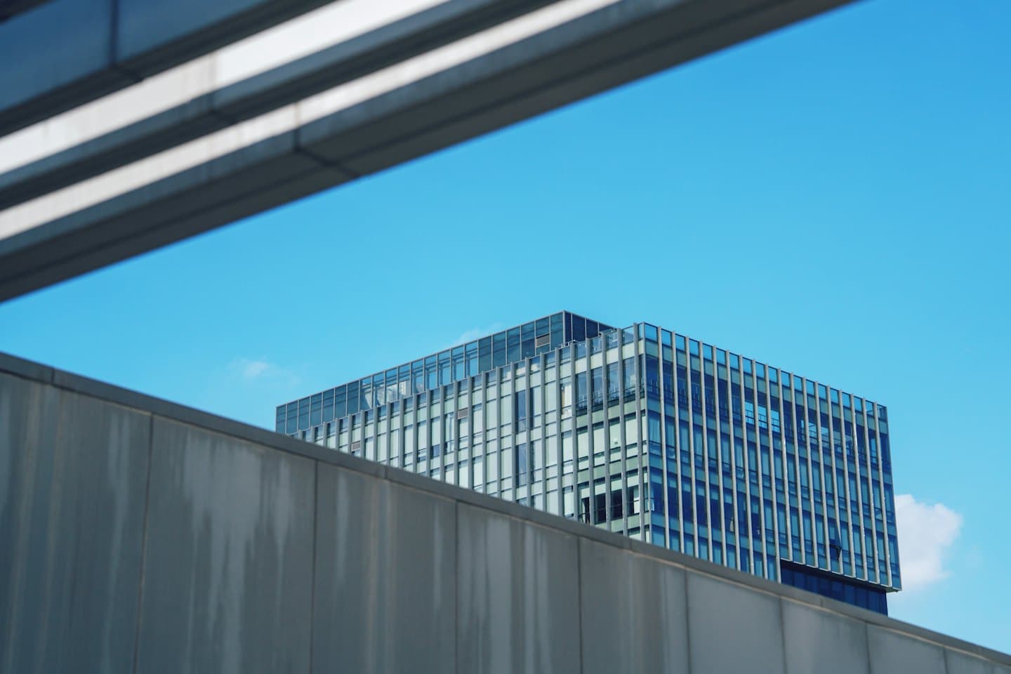 Moderno edificio per uffici in vetro sotto un cielo azzurro limpido.